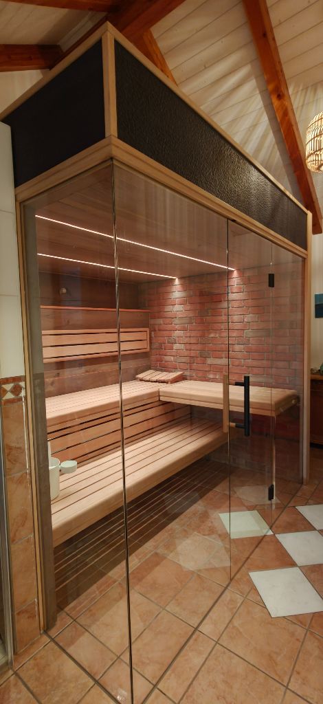 Sauna mit Backstein-Wand, Glasfront und Terrakotta-Fliesenboden