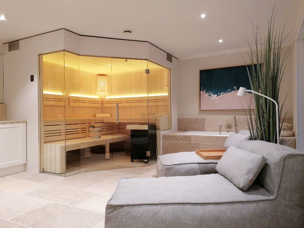 Wellness-Suite mit Sauna, Badewanne und Lounge-Sitzbereich
